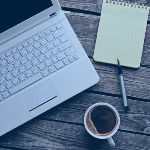 Computer coffee and notepad on table