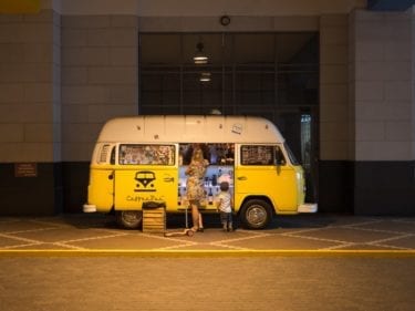 Food truck with woman and child ordering at night