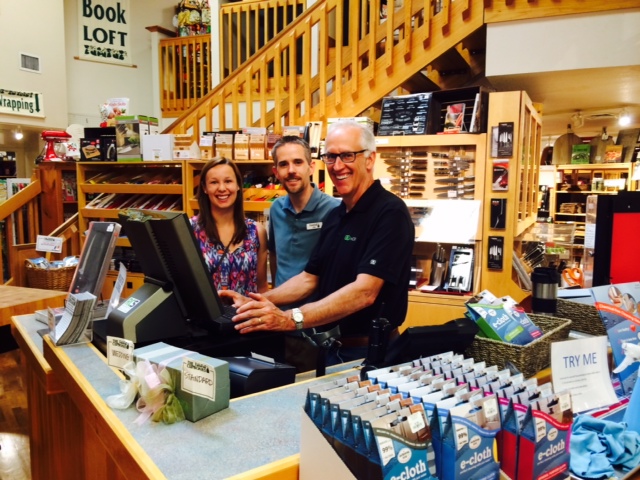 Dave and Casey Albert with a cashier at a register