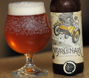 Myrcenary beer in a glass next to the bottle