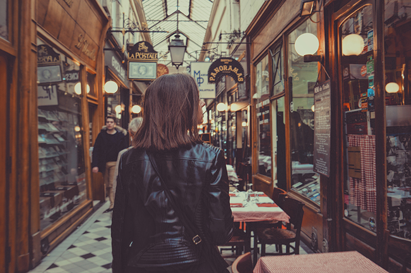 A young woman in a leather jacket shopping in a market.