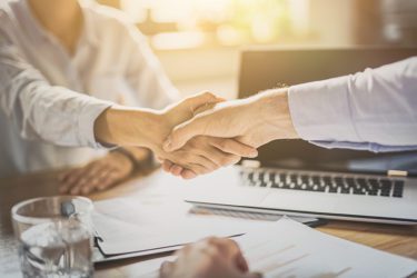 Business people shaking hands, finishing up meeting. Successful businessmen handshaking after good deal.