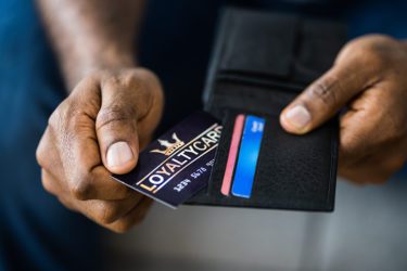 Man holding loyalty card and wallet
