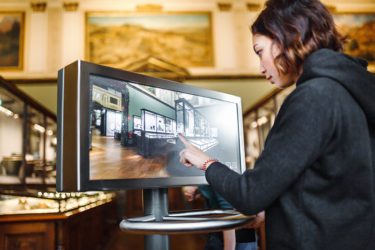 Woman using a touchscreen to navigate a museum