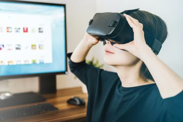 Woman with VR headset in front of computer