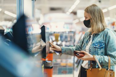 Woman holding wallet at self-scheckout