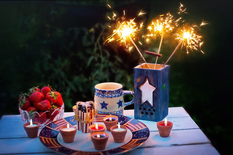 Sparklers, Strawberries, candles on a table for the 4th of July
