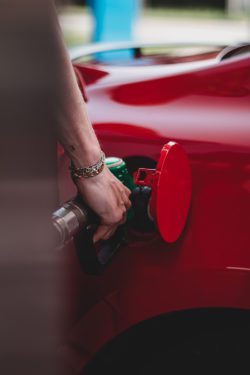 Person pumping gas into their red car