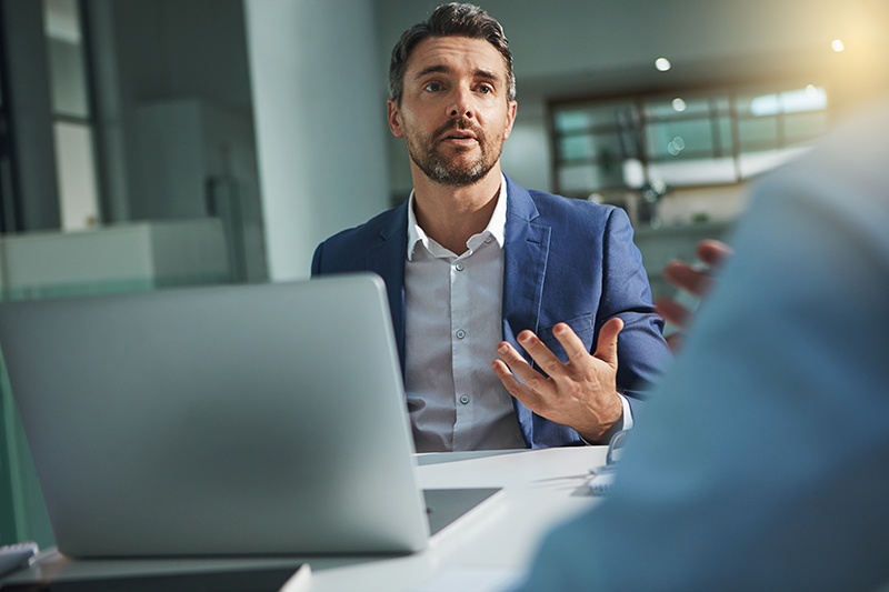 Man consulting with another person during a meeting in an office