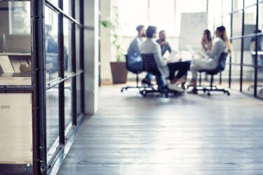 Group of people having a quarterly business review at a table in an office