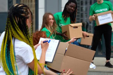 Group of volunteers holding boxes of food donations.