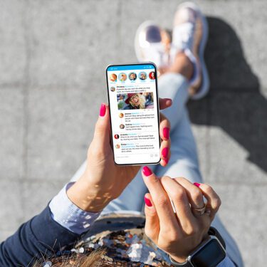 Top down image of a woman using social media app on her phone.