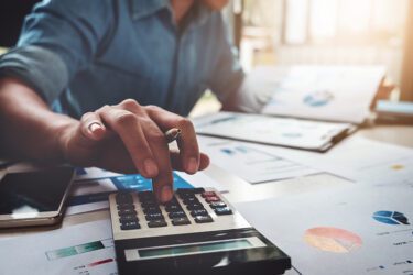 Person using a calculator to track their accounting information.