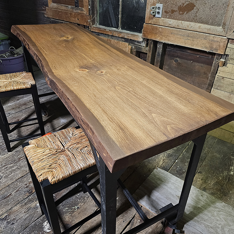 A wood table with two metal stools.