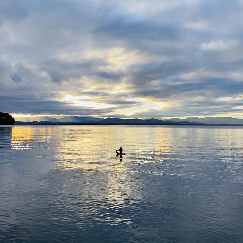 Jill swimming in Lake Champlain at sunset.