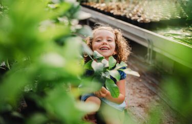 Portrait of cute small girl standing in the garden center.