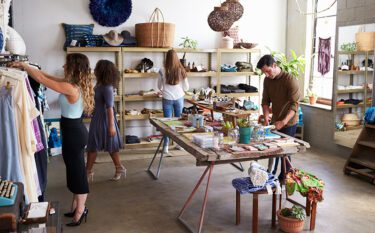 Customers and staff in a busy small business clothes shop