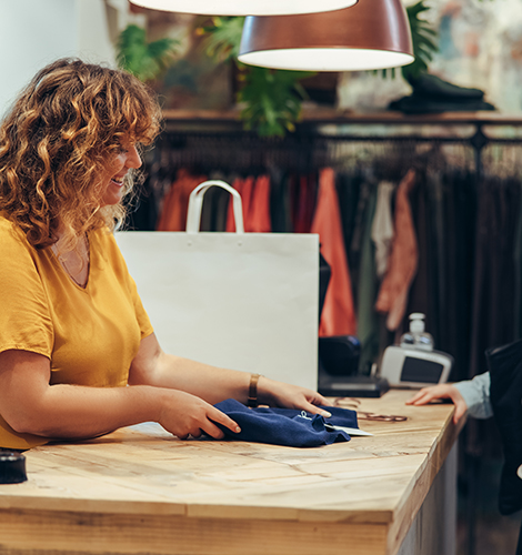 Shop clerk assisting a customer at the counter in a thrift shop.