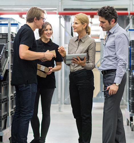 A team of employees reviewing data on a tablet in a storage facility