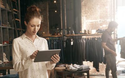 Saleswoman using a tablet to look up an item in a retail store.