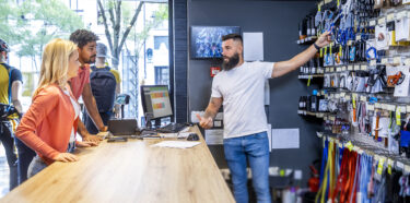 Neighbourhood small business A Female and Male customer in a retail store looking at product with a cashier. NCR Counterpoint point of sale software is displayed on the register in the background.